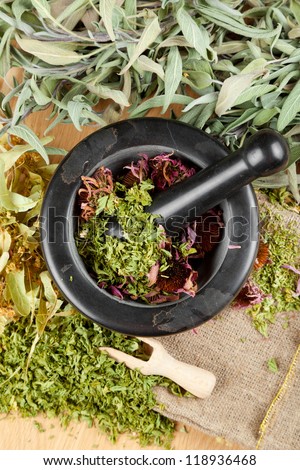 healing herbs on wooden table, mortar and pestle, herbal medicine, top view