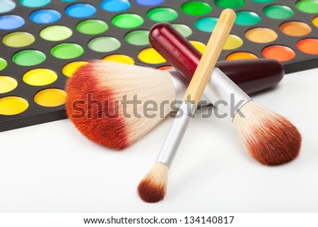 makeup brushes and set of colorful eye shadows