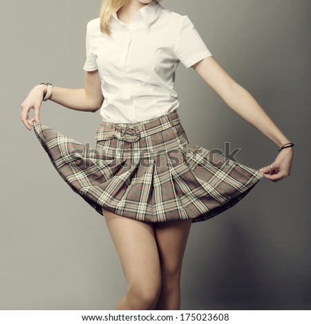 young lady lifting up her short plaid skirt