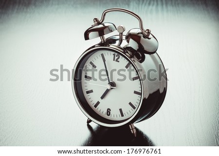 metallic Alarm clock on dark bedside table