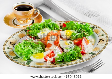 meal of salmon,eggs, tomatoes, lettuce, coffee cup and newspaper on table