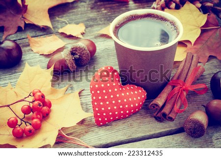 warming coffee cup, red heart and autumn still life on old table