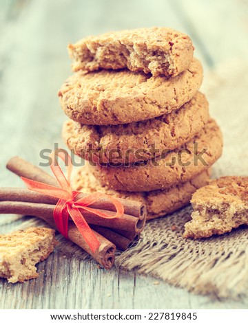 homemade oat cookies and cinnamon sticks on old table