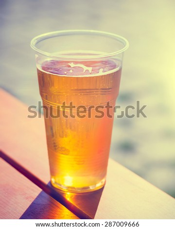 Retro styled photo of beer cup on table