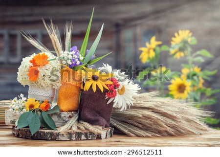 Wedding decoration in rustic style. Still life with summer flowers in a bags and ears of wheat.