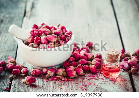 Mortar with rose buds and essential roses oil. Selective focus.
