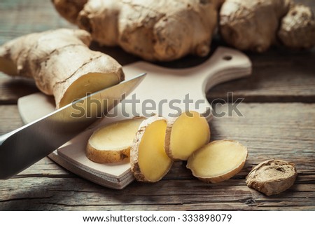 Chopped ginger root on cutting board on rustic wooden rustic table. Selective focus.