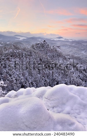 Frost and frozen deep snowy forest valley during the sunrise in the national park Bohemian Switzerland