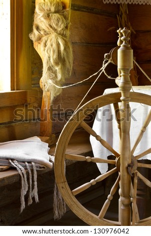 vintage traditional spinning wheel, distaff with yarn in wooden home interior