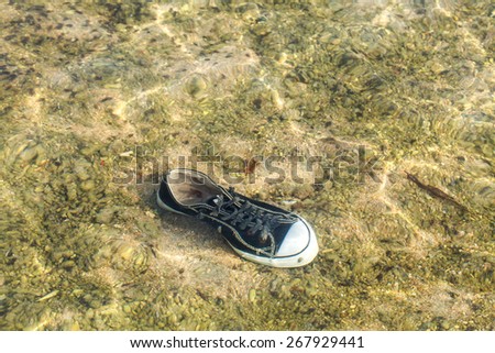 black sneakers in water,pollution