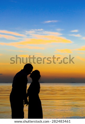 the couple silhouettes on beach twilight , blurry