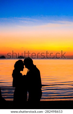 the couple silhouettes on beach twilight , blurry