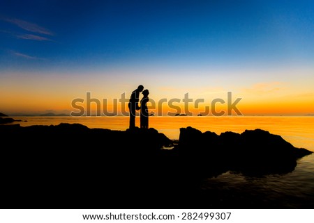 The couple silhouettes on beach twilight , blurry