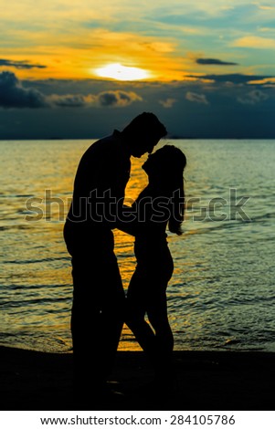 the couple silhouettes on beach sunset , blurry