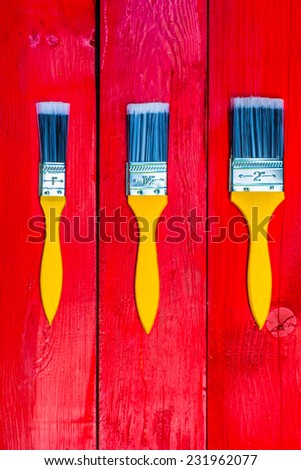 Three paint brushes lie on three boards