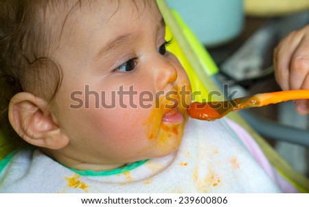 small child whose face is marred in baby food