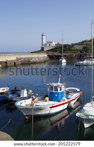 fishing boat in ventotene harbor and lighthouse