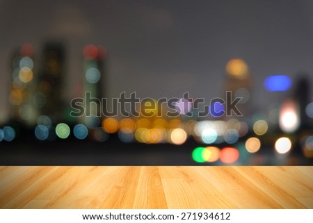 wood floor and abstract blurred city light from  chaopraya river,Bangkok Thailand