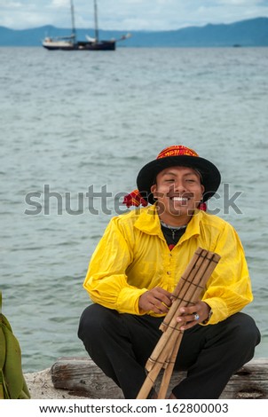 SAN BLAS ISLANDS, PANAMA - CIRCA JUNE 2006. Unknown native Kuna Indian man dressed  in native cerimonial attire playing a hand made flute in the San Blas Islands, panama, CIRCA June 2006.