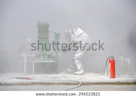 Firefighter in special suit during the fire drill in oil refinery