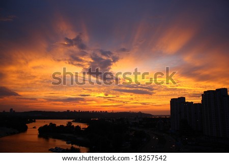 Silhouettes of the buildings and sunset rays in the sky.