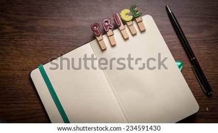 Concept of banking terms - Price word on clothes peg stick to notepad with pen on the side on wooden floor with room for text