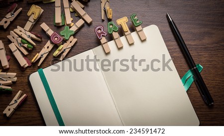Concept of banking terms - Rate word on clothes peg stick to notepad with pen on the side on wooden floor with room for text