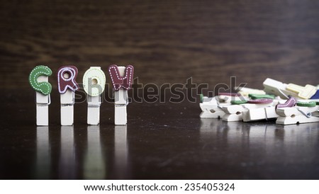 Common business terms - Slightly defocused and close-up of GROW word on clothes peg stick with lots of clothes peg at background