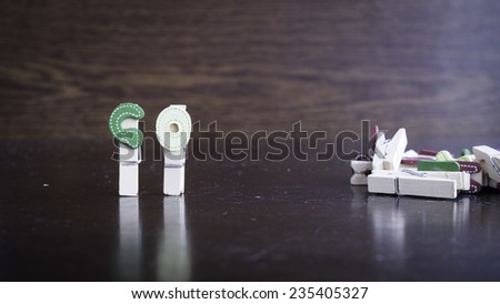 Common business terms - Slightly defocused and close-up of GO word on clothes peg stick with lots of clothes peg at background