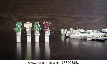 Common business terms - Slightly defocused and close-up of STAY word on clothes peg stick with lots of clothes peg at background