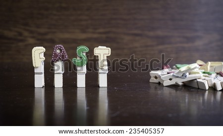 Common business terms - Slightly defocused and close-up of FAST word on clothes peg stick with lots of clothes peg at background