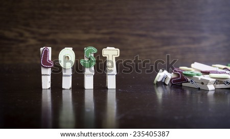 Common business terms - Slightly defocused and close-up of LOST word on clothes peg stick with lots of clothes peg at background