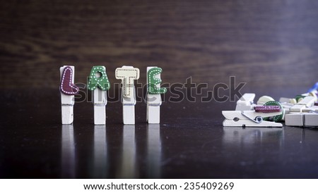 Common business terms - Slightly defocused and close-up of LATE word on clothes peg stick with lots of clothes peg at background