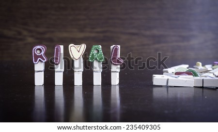 Common business terms - Slightly defocused and close-up of RIVAL word on clothes peg stick with lots of clothes peg at background