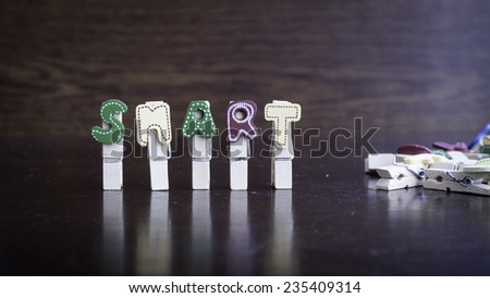 Common business terms - Slightly defocused and close-up of SMART word on clothes peg stick with lots of clothes peg at background