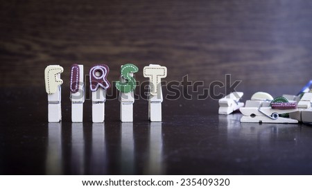 Common business terms - Slightly defocused and close-up of FIRST word on clothes peg stick with lots of clothes peg at background