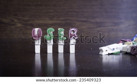 Common business terms - Slightly defocused and close-up of USER word on clothes peg stick with lots of clothes peg at background