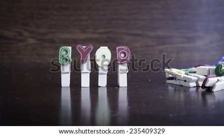 Common business terms - Slightly defocused and close-up of BYOD word on clothes peg stick with lots of clothes peg at background