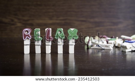 Common business terms - Slightly defocused and close-up of RELAX word on clothes peg stick with lots of clothes peg at background