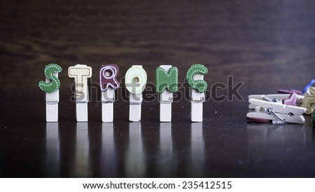 Common business terms - Slightly defocused and close-up of STRONG word on clothes peg stick with lots of clothes peg at background