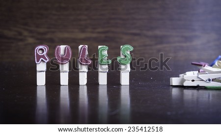 Common business terms - Slightly defocused and close-up of RULES word on clothes peg stick with lots of clothes peg at background