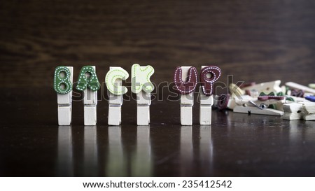 Common business terms - Slightly defocused and close-up of BACK UP word on clothes peg stick with lots of clothes peg at background