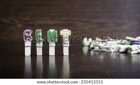 Common business terms - Slightly defocused and close-up of RENT word on clothes peg stick with lots of clothes peg at background