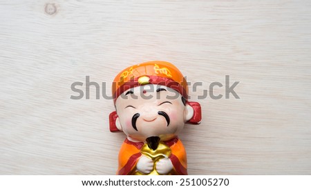 God of prosperity doll or Deity figurine holding a message \'Prosperity\' and \'Money and Fortunes Come\'. Concept of Chinese Lunar New Year. Slightly defocused and close-up shot. Copy space.