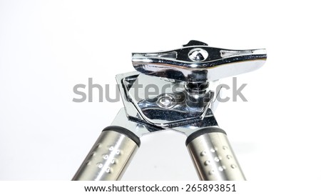 Stainless steel silver metal tin and can opener on empty background. Concept of modern and simplistic kitchen utensil. Slightly de-focused and close-up shot. Copy space.