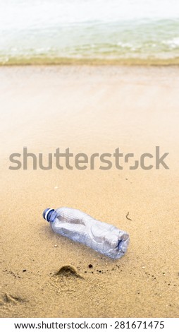 An empty plastic mineral water bottle on clean and empty beach