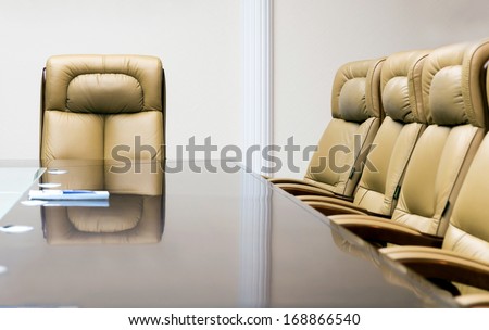 conference room with wooden table and beige leather armchairs
