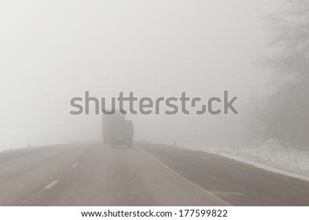 trucks driving on an extremely  foggy road