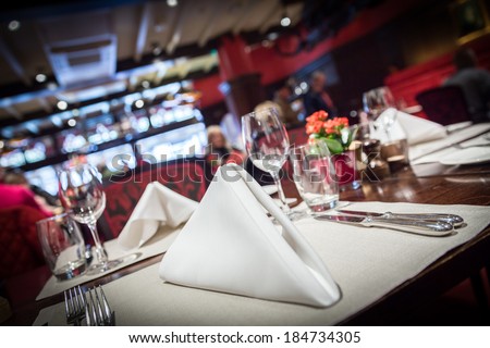 Empty glasses set with napkin in fine dining restaurant decorated in red style