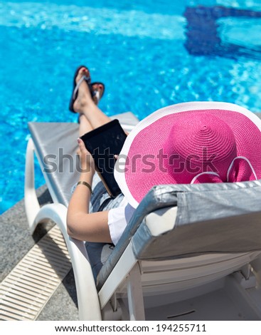 Woman on sunbed waering beautiful pink hat